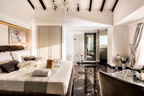 a bedroom with a bed and a tub and a chandelier at Mare suites 1 in Chania Town
