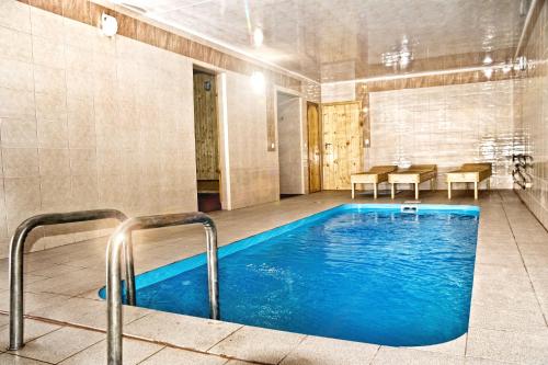 a large pool in a room with a table and chairs at Kolyba Complex in Uman