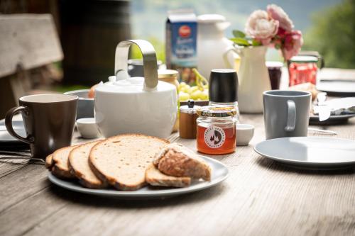 einen Tisch mit einem Teller Brot und Kaffeetassen in der Unterkunft Chalet Abnona in Wieden