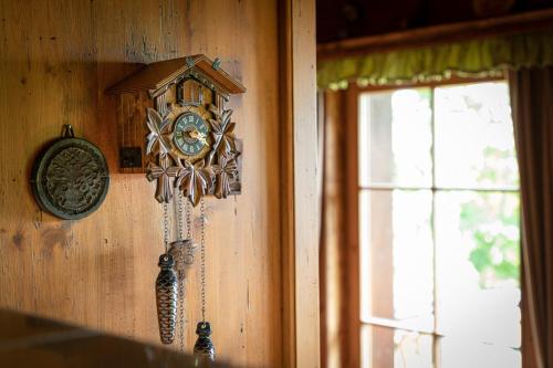 a clock hanging on a wall next to a window at Chalet Abnona in Wieden