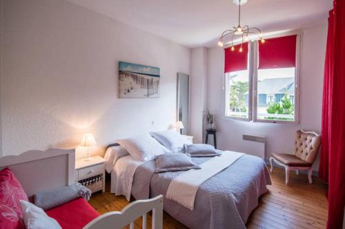 a bedroom with two beds and a desk and a couch at Sables d'or Bel Appartement 300 m de la plage in Fréhel