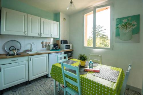 a kitchen with a table and a table and chairs at Sables d'or Bel Appartement 300 m de la plage in Frehel