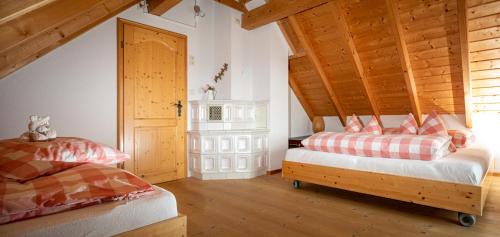a bedroom with two beds and a wooden ceiling at Chalet Abnona in Wieden