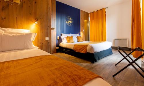 una camera d'albergo con due letti e pareti blu di Grand Hôtel 1899 a Langogne