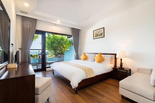 a bedroom with a large bed and a large window at Hoang Ngoc Beach Resort in Mui Ne