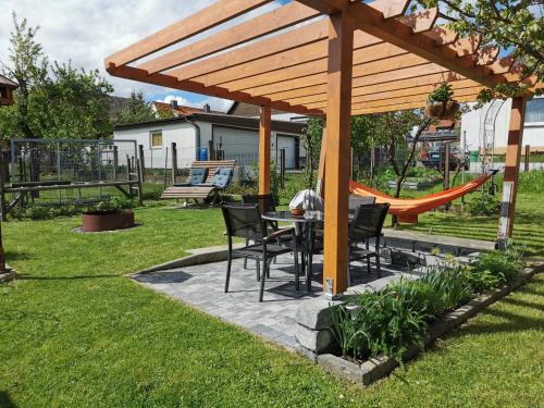 a patio with a table and chairs under a wooden pergola at Ferienwohnung Oliver in Fritzlar
