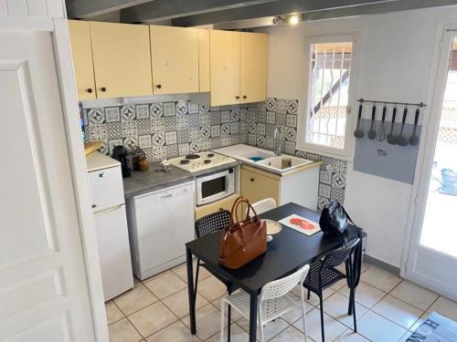 une petite cuisine avec une table et une table dans l'établissement SUN, à Portiragnes