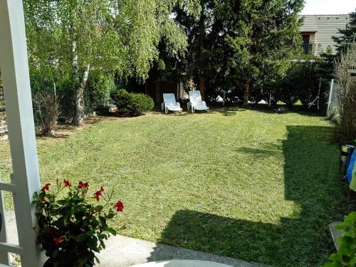 a yard with two chairs in the grass at Holiday Home Balatonszárszó in Balatonszárszó