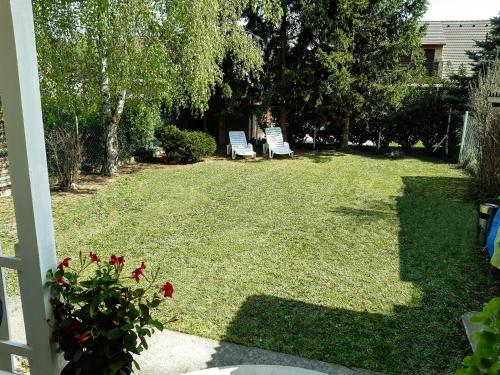 podwórze z dwoma krzesłami w trawie w obiekcie Holiday Home Balatonszárszó w mieście Balatonszárszó