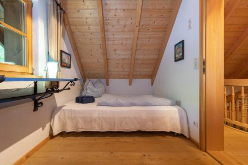 a small bed in a room with wooden ceilings at Chalet Abnona in Wieden