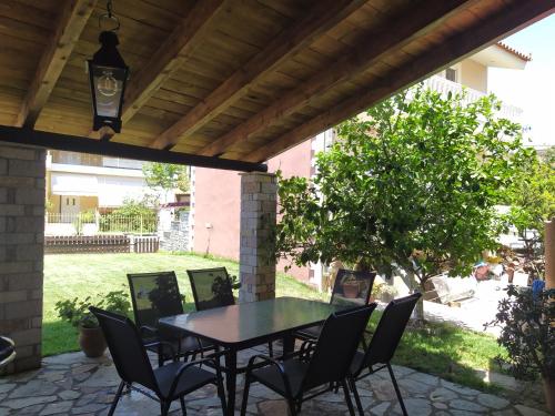 a patio with a table and chairs under a pergola at Chara host in Olympia