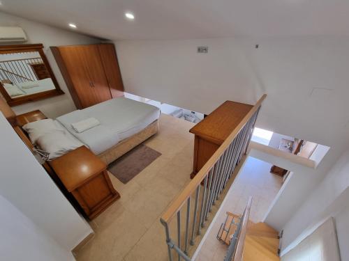 Habitación pequeña con cama y escalera en Atico Cesar Elguezabal, en Alicante