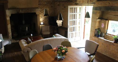 une pièce avec une table avec un vase de fleurs dessus dans l'établissement La maison de César Les Eyzies de Tayac, à Sireuil