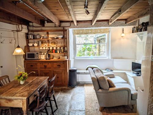 a living room with a table and a couch at The Hideaway in Falmouth