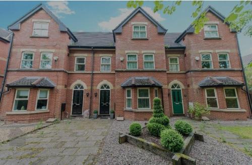 a large brick house with a courtyard in front of it at Morning Glory in Bolton