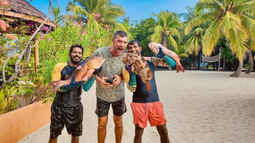 a group of three men standing on the beach at Sabba Beach Suite , Fodhdhoo - Maldives in Velidhoo