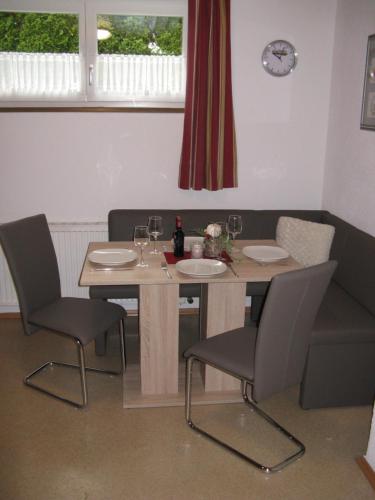 ein Esszimmer mit einem Tisch und Stühlen mit Weingläsern in der Unterkunft Haus Falkner Barbara in Umhausen