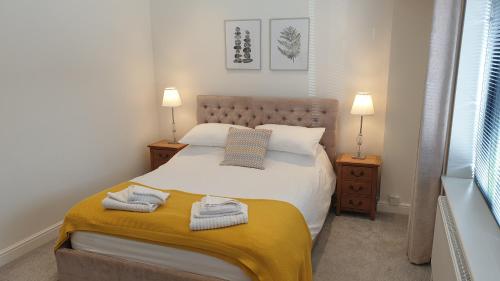a bedroom with a bed with two towels on it at Large modern self contained apartment in Lymington in Lymington