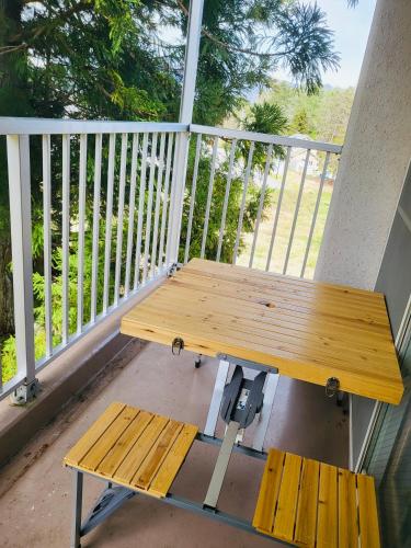 a wooden picnic table and bench on a porch at Hakuba Inn Bloom in Hakuba