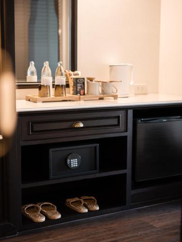 a bathroom with a vanity with shoes under a sink at Burirattana Hotel-An Adults Only Hotel in Chiang Mai