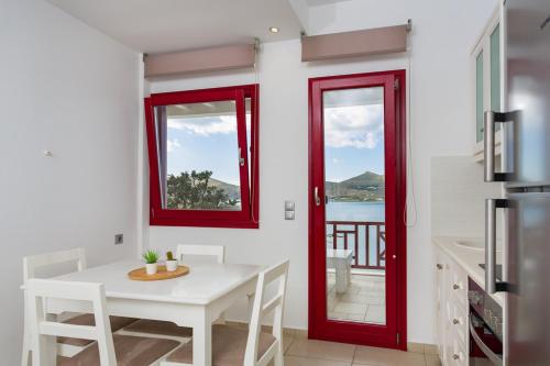a kitchen with a white table and red windows at Katerina mare in Naousa