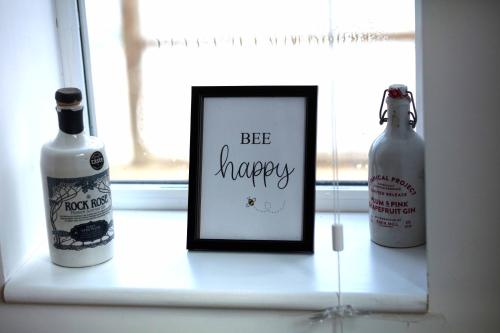 two bottles of wine and a picture in a window at Beautiful rural cottage with secure garden in Bradley