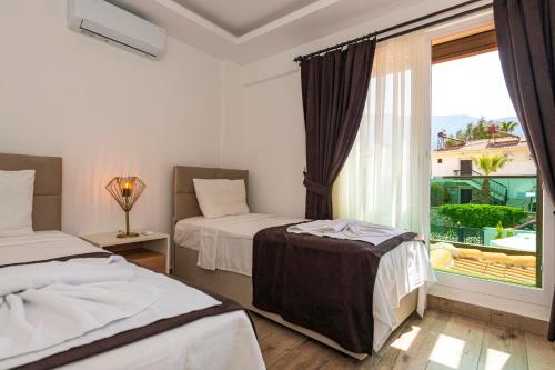 a hotel room with two beds and a window at 4 Beds, Luxury Holiday Villa in Hisarönü Ölüdeniz Villa Mia in Fethiye
