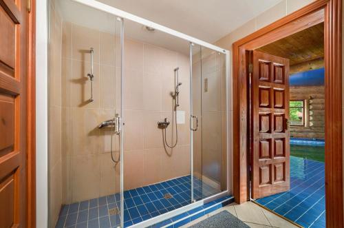 a bathroom with a shower with a glass door at Saules sēta 