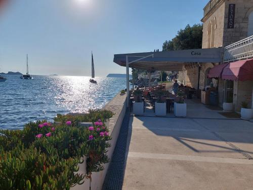 a restaurant next to a body of water with flowers at Blue Promenade Apartments in Dubrovnik