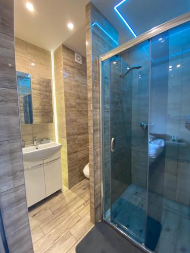 a bathroom with a glass shower and a sink at Pokoje Gościnne Ilona in Gdańsk