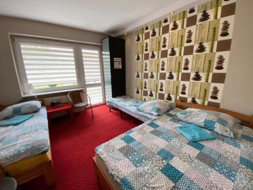 a hotel room with two beds and a window at Pokoje Gościnne Ilona in Gdańsk