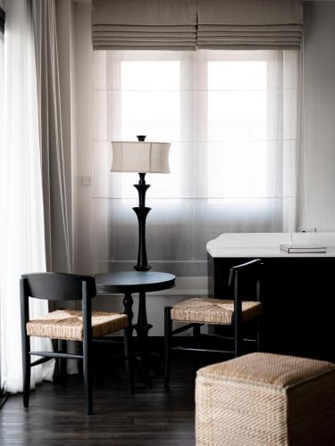 a table and two chairs and a lamp in a room at Burirattana Hotel-An Adults Only Hotel in Chiang Mai
