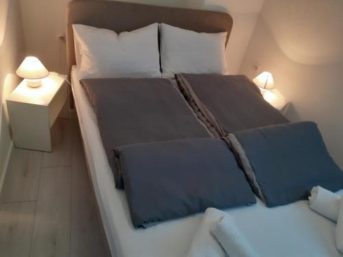 sypialnia z dużym łóżkiem z niebieską pościelą i poduszkami w obiekcie Studio apartman LORENA w mieście Zadar