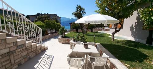 a patio with a table and chairs and an umbrella at Residence La Cioca in Malcesine
