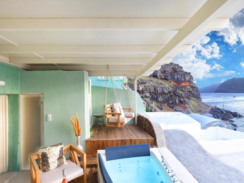 a room with a balcony with a view of the ocean at Secret Gem Suites in Oia
