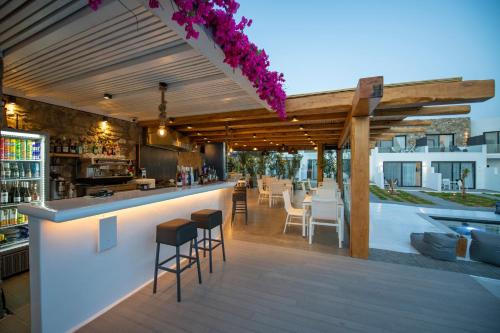 an outdoor bar with stools and tables and chairs at Bianco a Nero Mykonos in Mýkonos City
