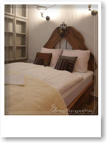 una camera da letto con un grande letto con lenzuola e cuscini bianchi di Wellnesska Vyhne a Vyhne