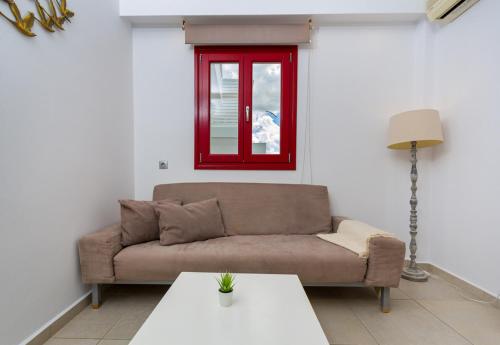 a living room with a couch and a red window at Katerina mare in Naousa