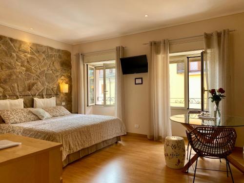 um quarto com uma cama, uma mesa e cadeiras em Locanda Nelia Guest House em Baveno