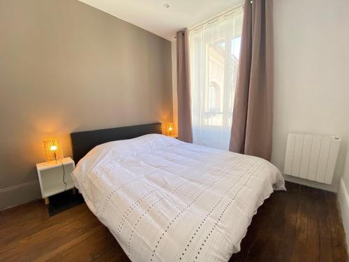 a bedroom with a white bed and a window at Le Cosy in Melun
