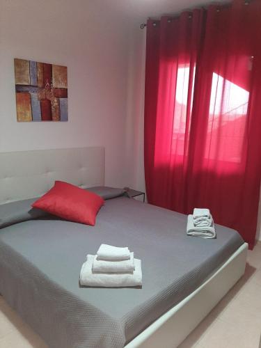 1 dormitorio con 1 cama con cortina roja en Guesthouse Loru, en Sestu