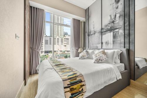 een slaapkamer met een bed met een groot raam bij M-aple by Kozystay - Setiabudi in Jakarta