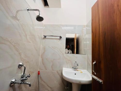 ein Bad mit einem Waschbecken und einem Spiegel in der Unterkunft Nomads House in Dehradun