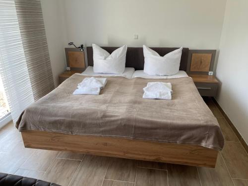 a bedroom with a large bed with white pillows at Die 1A Pension in Welsau