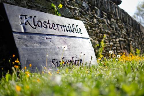 a stone wall with a sign that reads kassociation at Hotel Klostermühle Siebenborn in Maring-Noviand