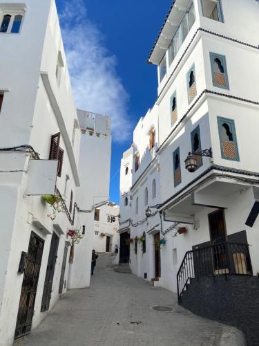 an alley between two white buildings at Lilac's Garden Cabo Negro in Cabo Negro