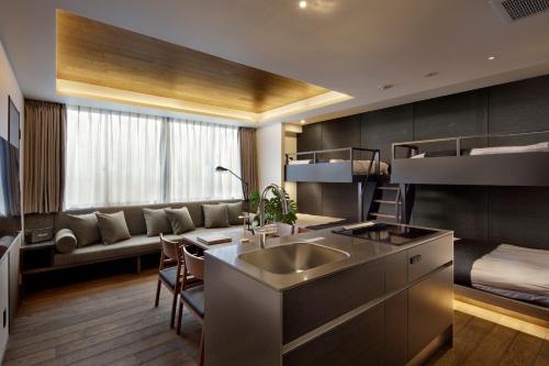 a kitchen with a sink and a living room with a couch at 20 PIECES in Kyoto