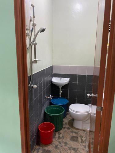 a bathroom with a toilet and a sink and buckets at Publikhaus in Caliclic