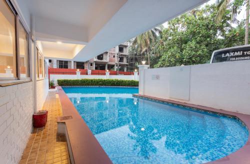 a swimming pool with blue water in a building at Arotel Rooms & Suites in Calangute