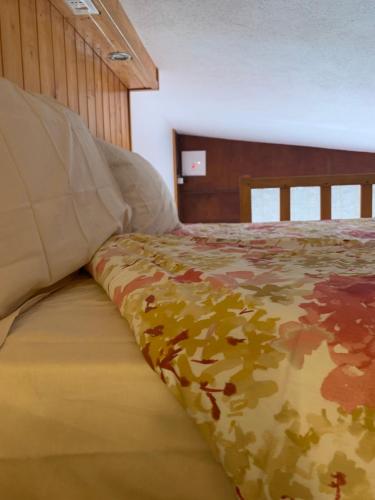 a bedroom with a bed with a camouflage blanket at Monolocale vista Cervino in Breuil-Cervinia